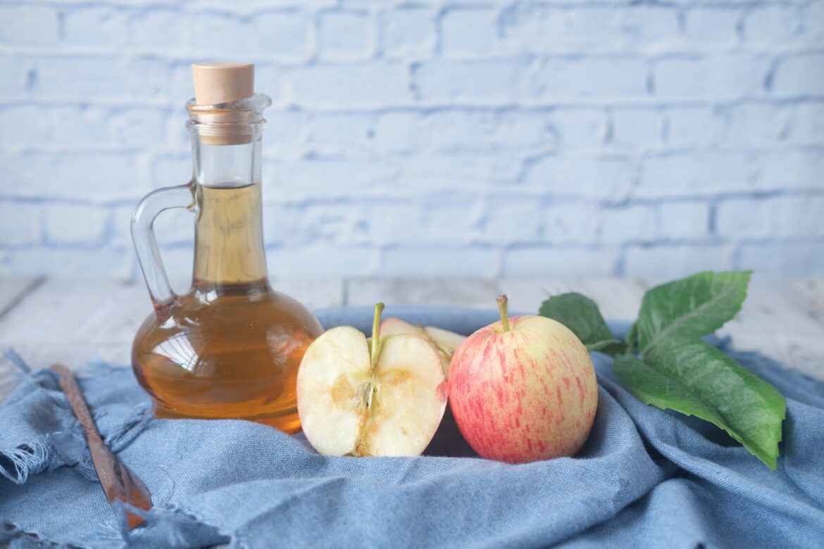 Apple cider vinegar bottle with apples beside