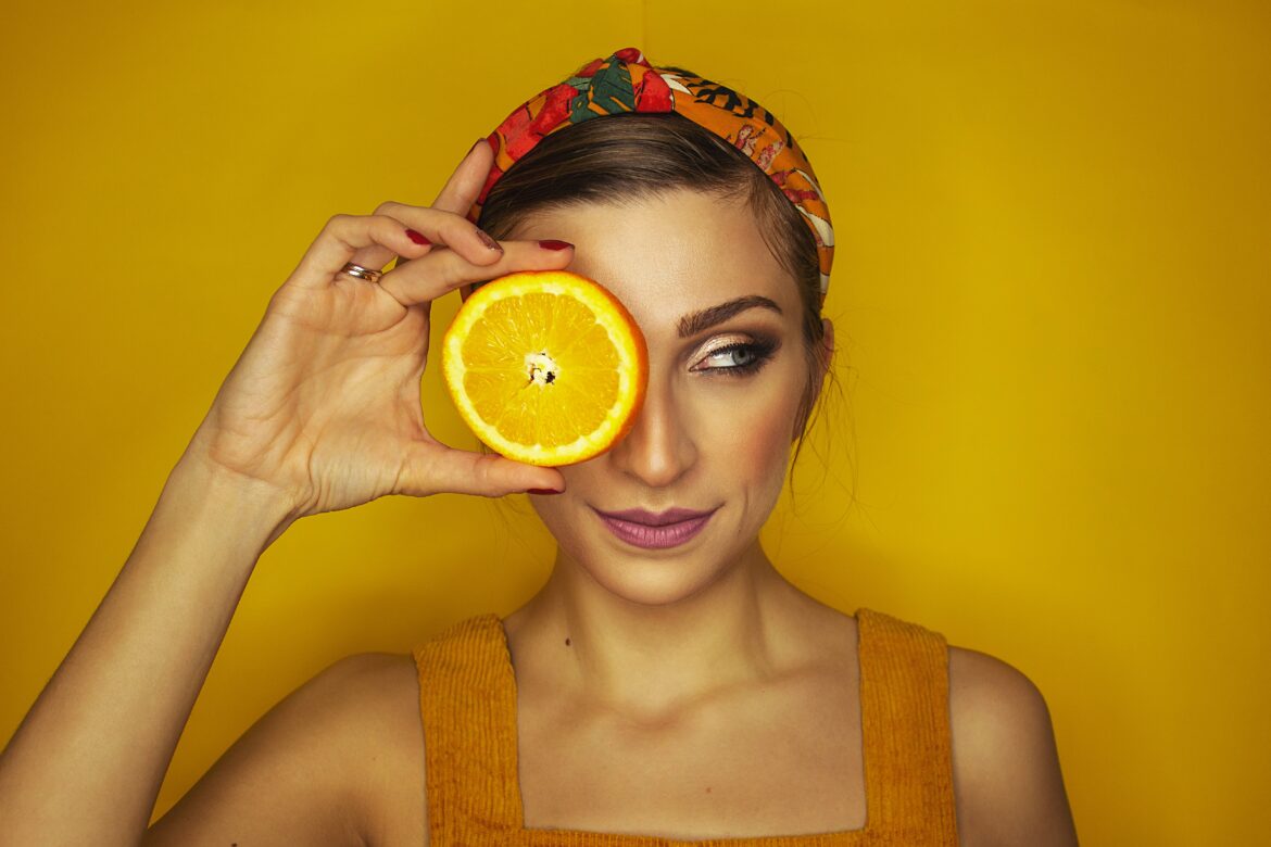 A women holding a peice of orange wearing an orange vest