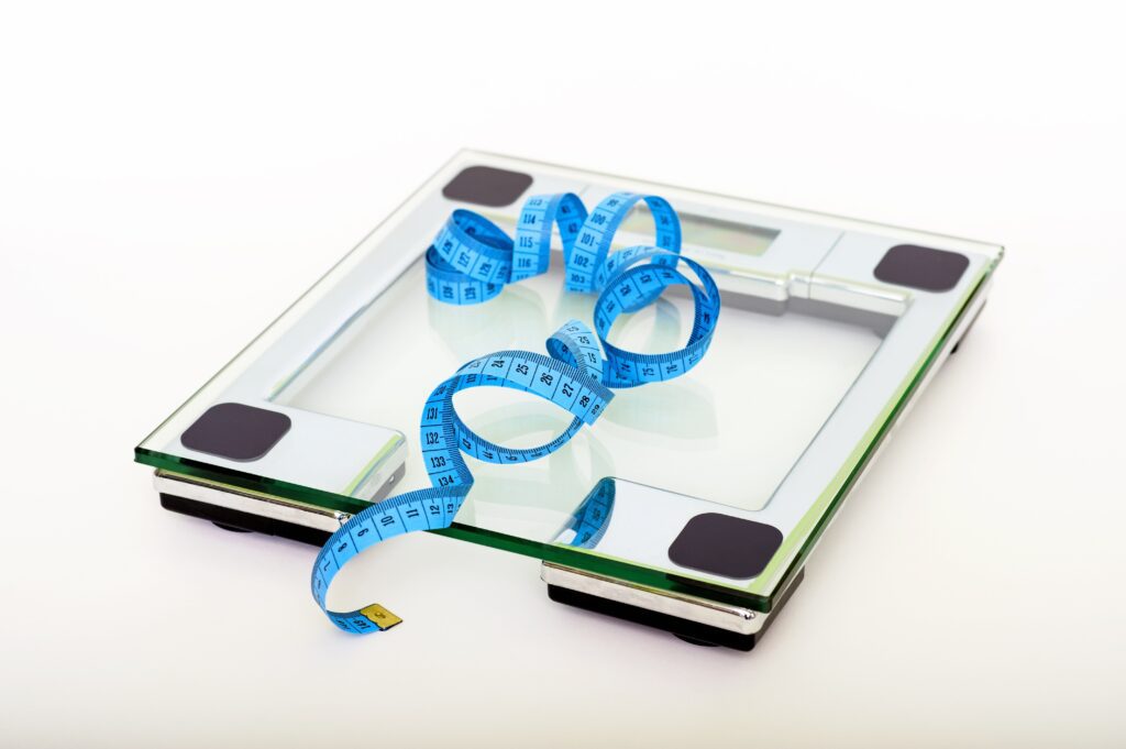 weight loss - weighing scale with measuring tape on it